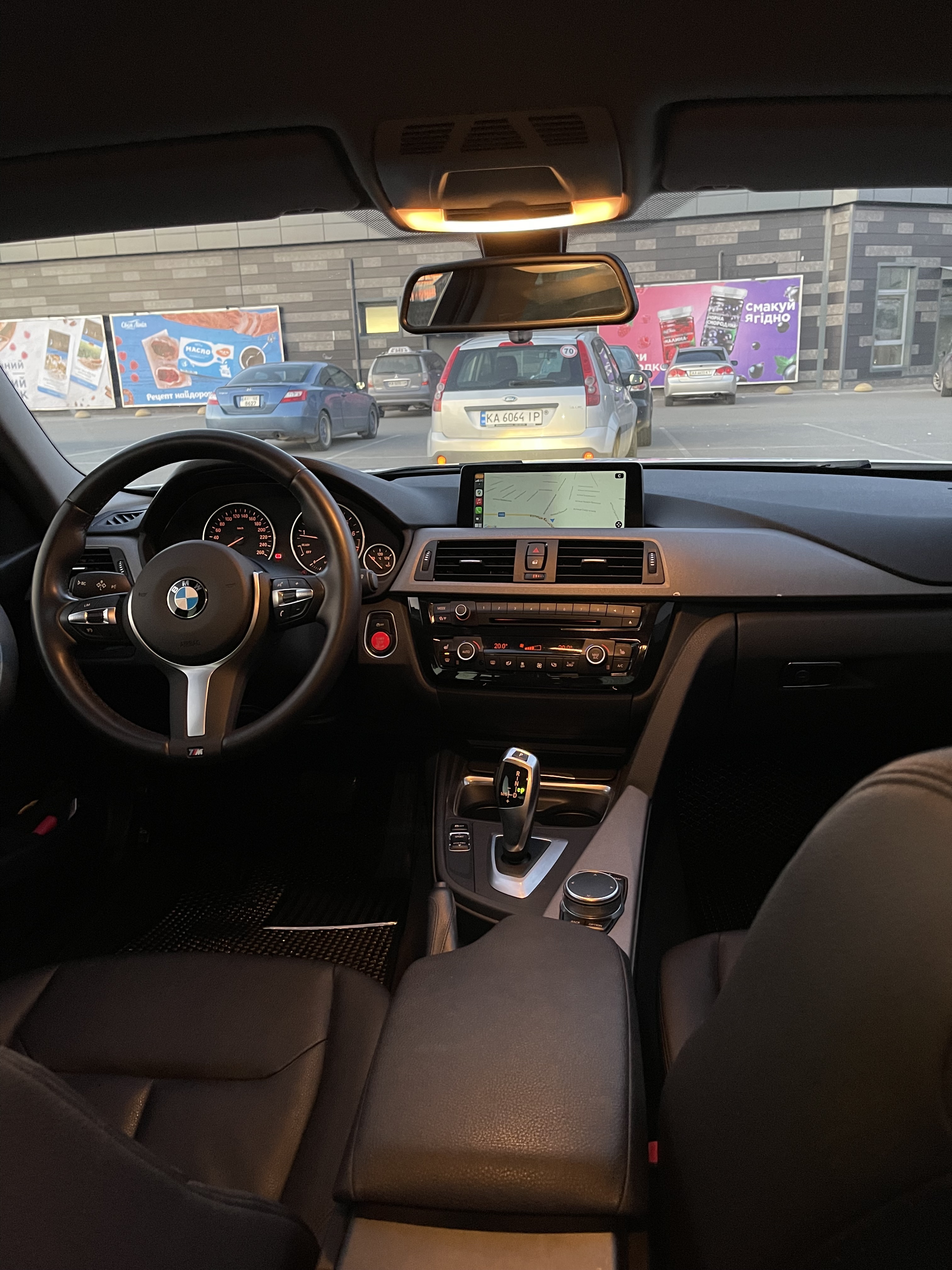 F30 interior with M steering wheel and NBT Evo screen showing CarPlay